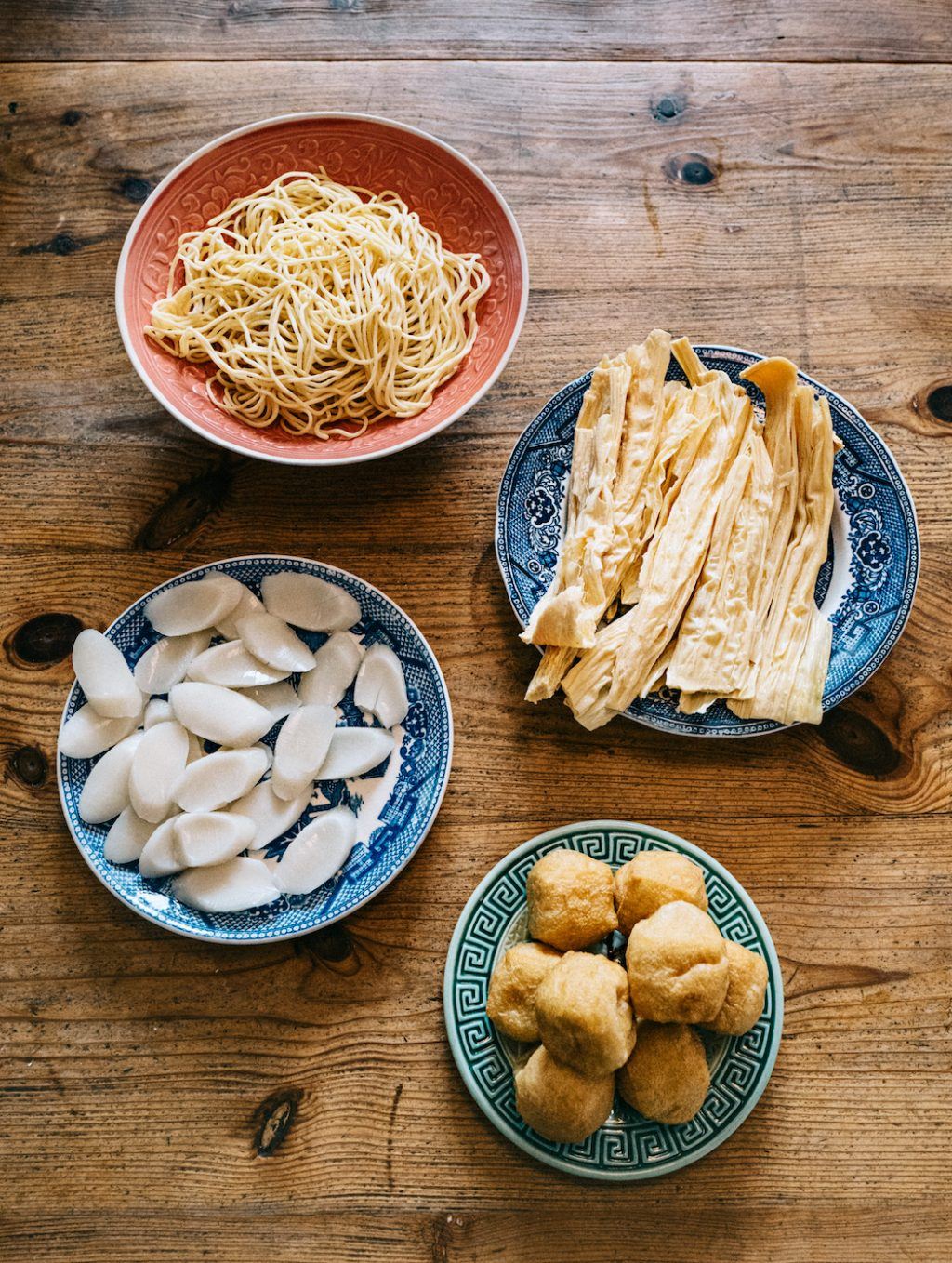 Nuudlar och tofu i tallrikar.