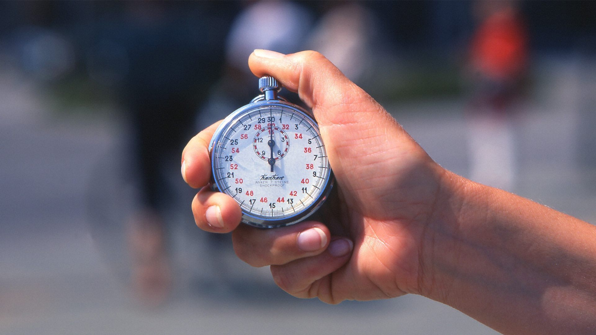 En hand som greppar ett tidtagarur