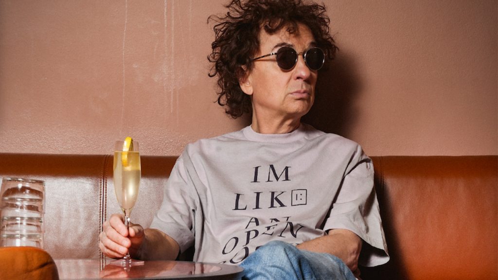 Magnus Uggla sittandes i en soffa med en drink på bordet.