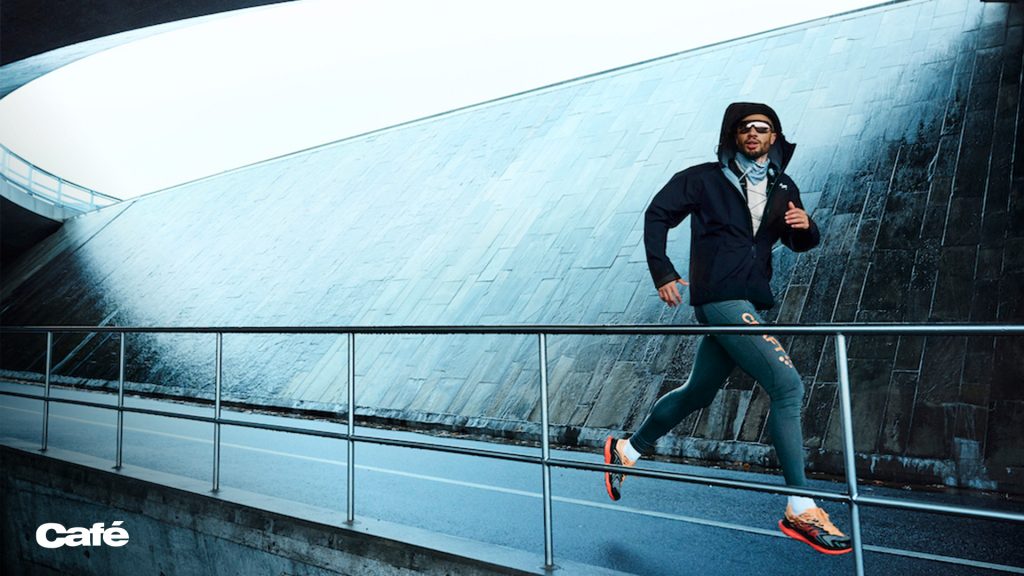 Trendigt klädd manlig löpare ute på en springtur.