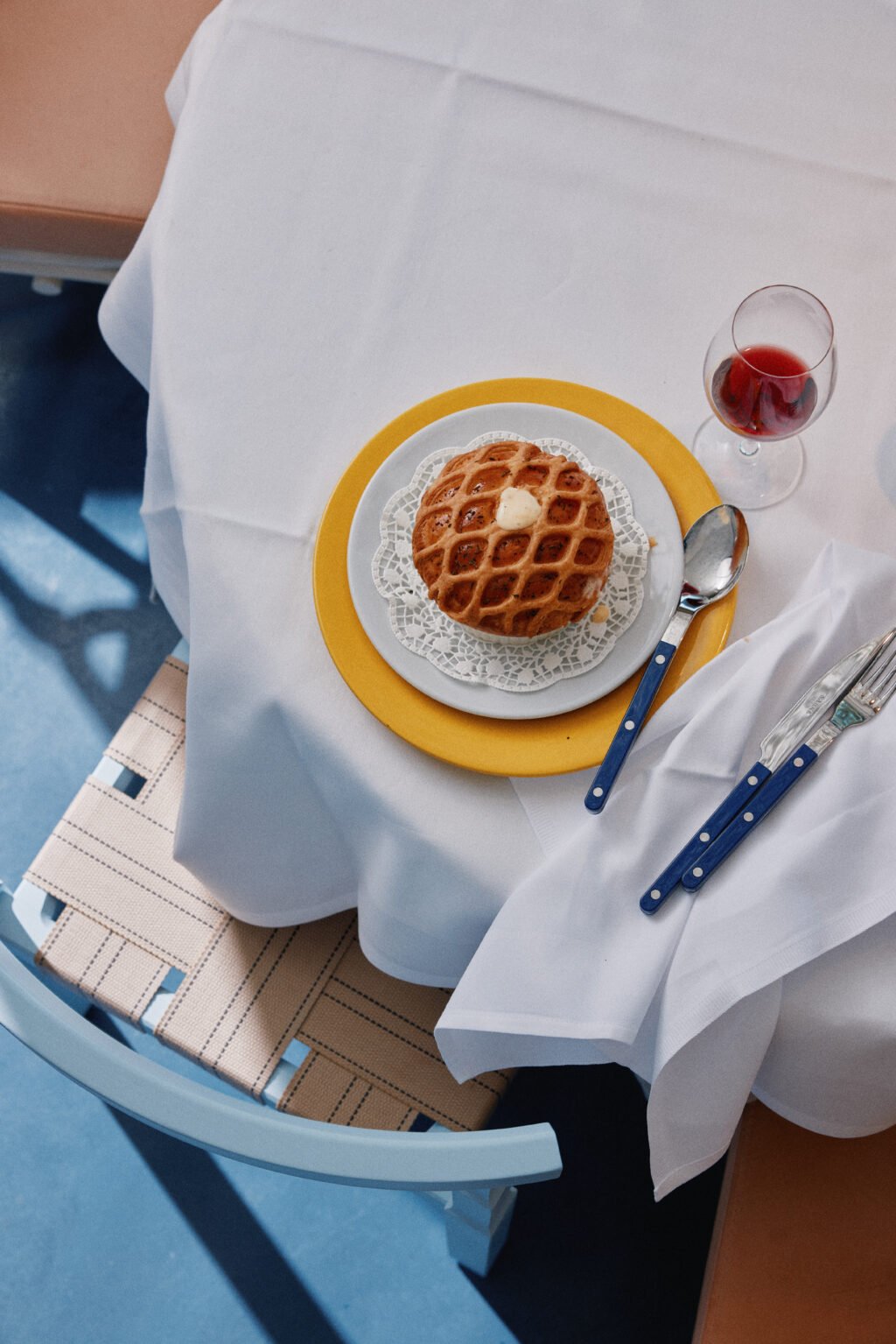 Löksoppa på bord med vit duk och ett glas rött vin.