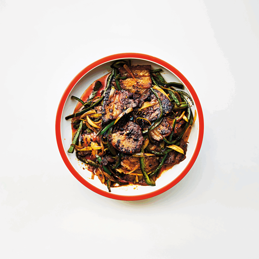 Dubbelstekt fläsk i vit tallrik med röd kant