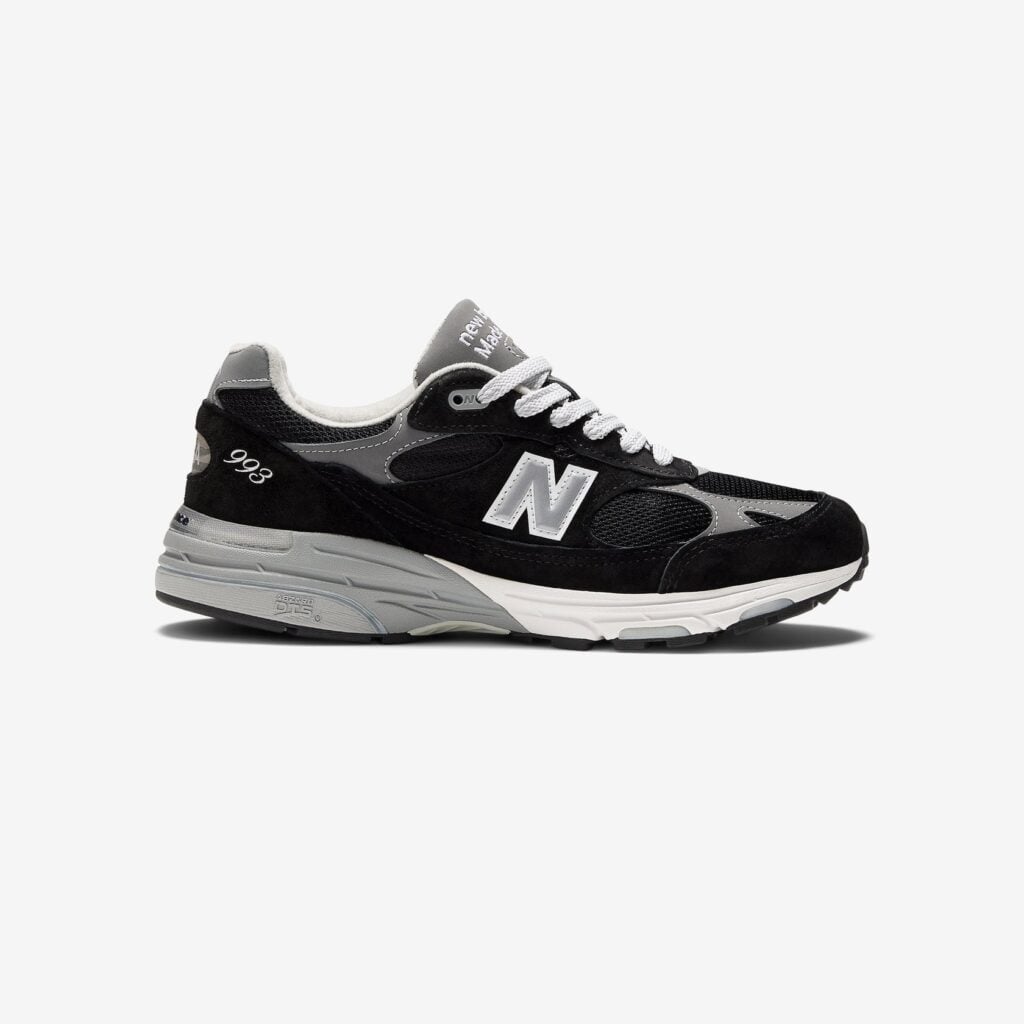 Made in USA 993-sko från New Balance sedd från sidan. Skon är svart med grå detaljer och har en rejäl sula.
